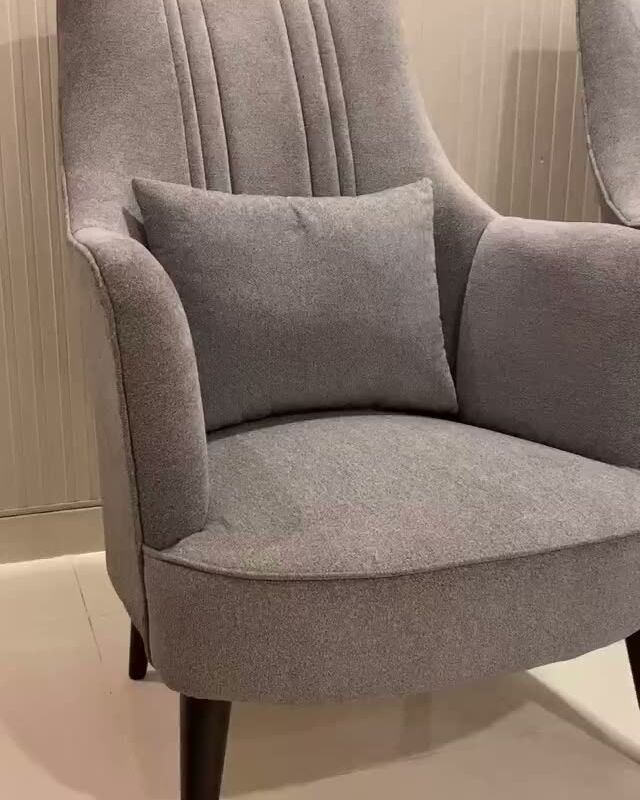 Grey wingback chair with dark wood legs